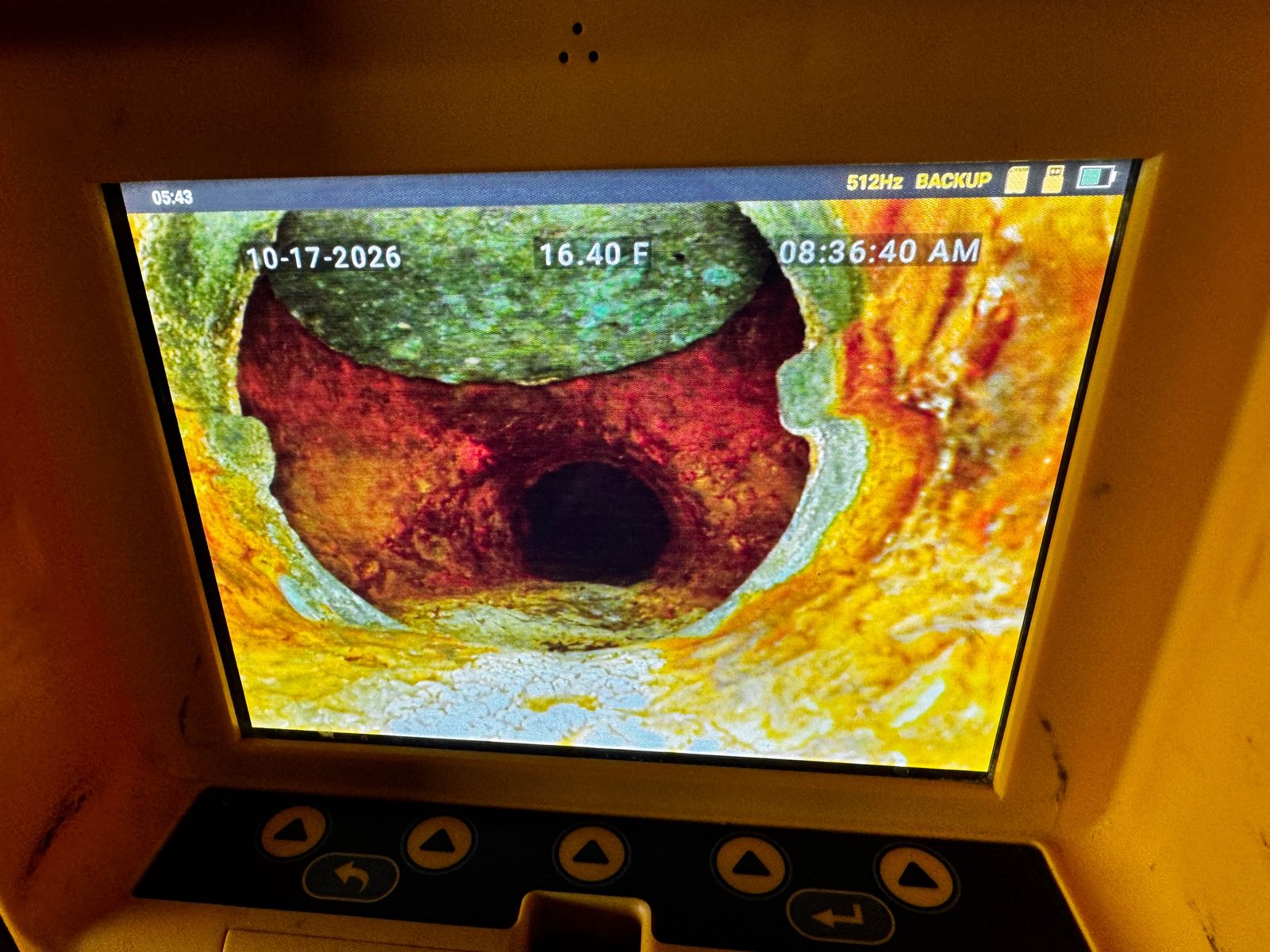 Sewer camera monitor showing a rusted backwater valve flap stuck open at 16.40 feet