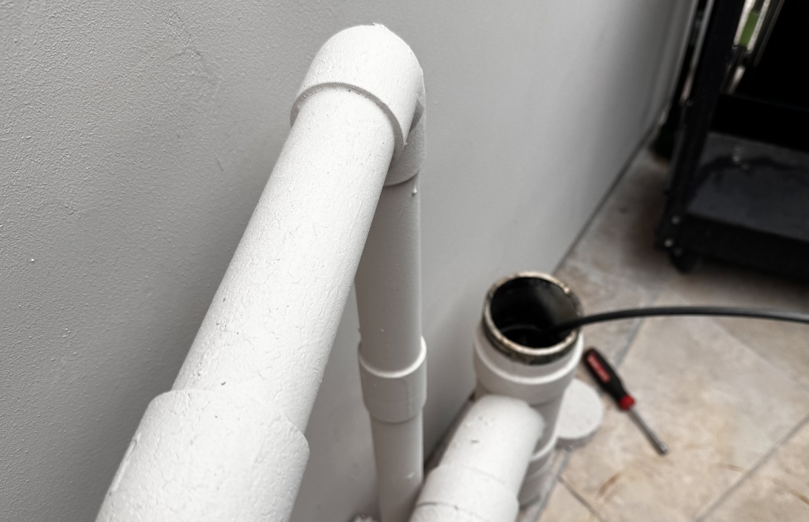 Sewer camera cable feeding into an interior cleanout access point during an inspection