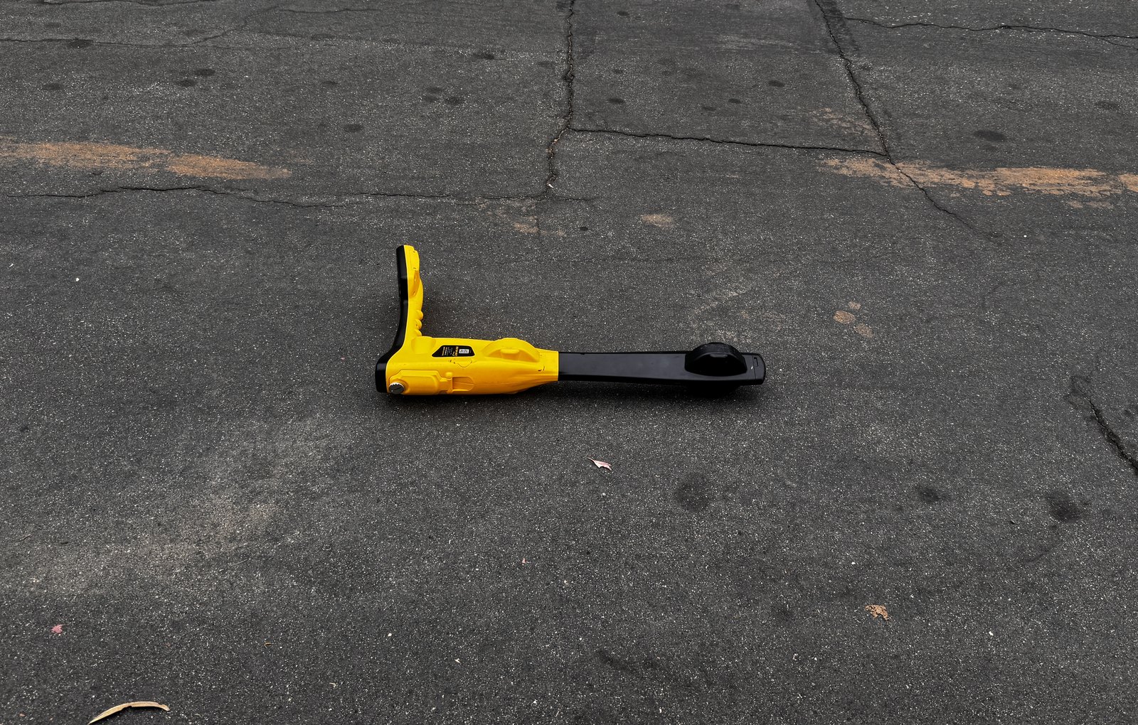 Sewer line locator wand on street pavement during a main line trace
