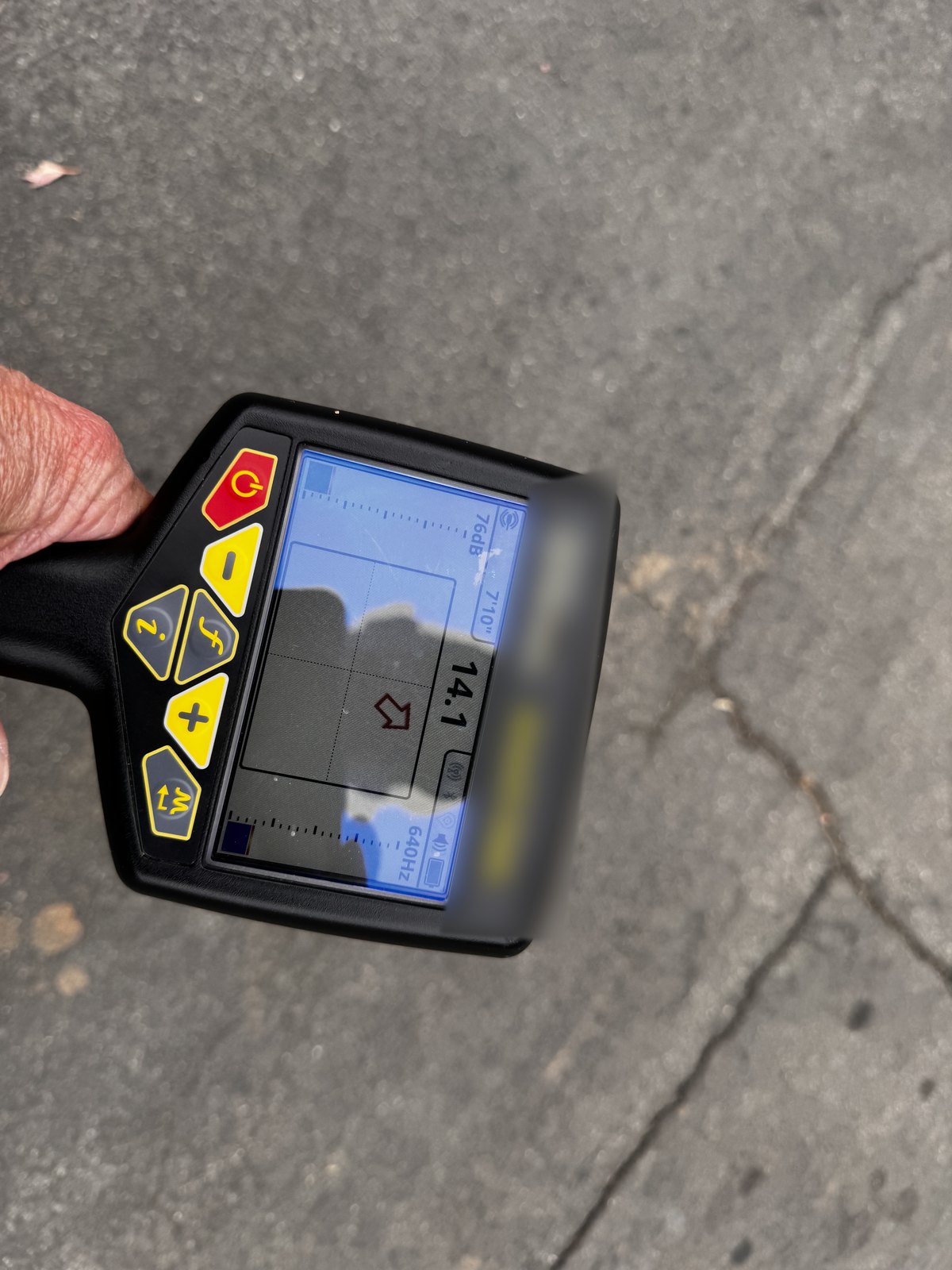 Handheld sewer line locator receiver showing signal strength and depth reading during a main line locate