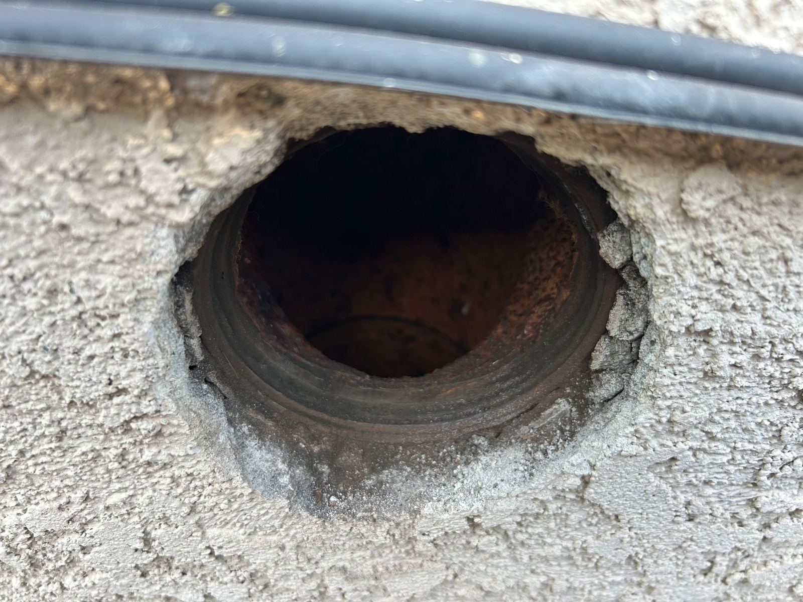 Open sewer cleanout after the surrounding stucco was chipped away