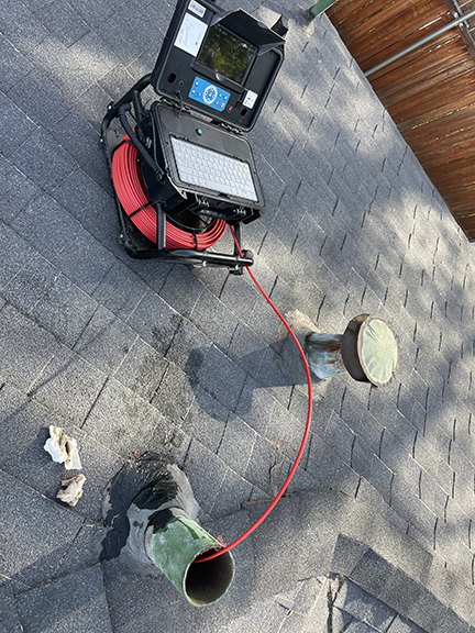 FlowPro IE sewer scope camera being fed through a roof vent access point during a residential sewer inspection in Riverside CA