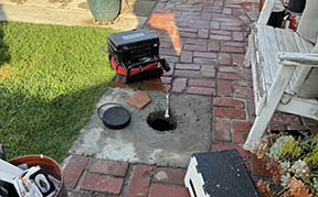 FlowPro IE sewer scope camera being fed into a clean-out access point during a residential sewer inspection in San Bernardino CA